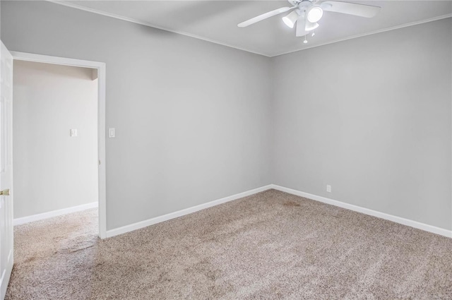 carpeted empty room featuring baseboards, a ceiling fan, and ornamental molding