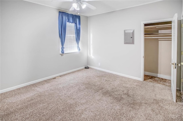 unfurnished bedroom featuring electric panel, baseboards, carpet floors, and a closet