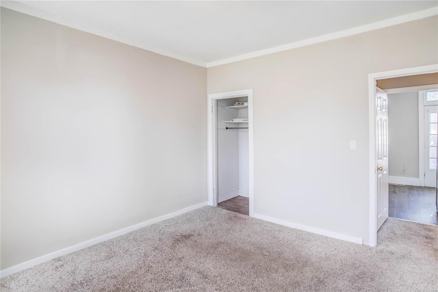 unfurnished bedroom featuring a closet, baseboards, carpet, and ornamental molding