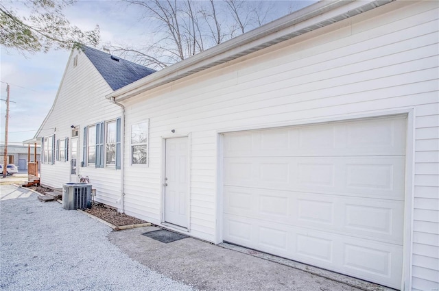 view of side of home with central air condition unit and a garage