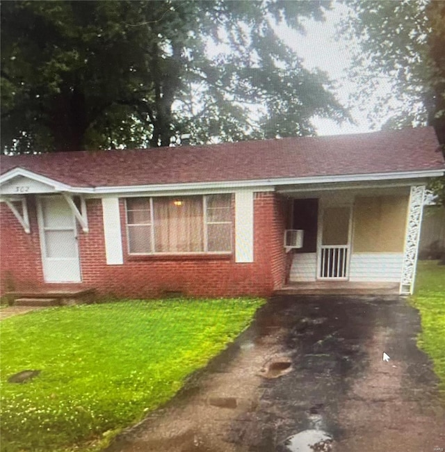 single story home with a front yard and brick siding