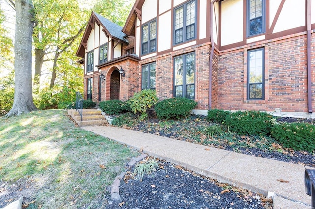 exterior space featuring brick siding and stucco siding