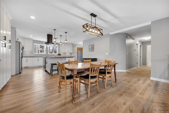 dining area with light wood finished floors, recessed lighting, visible vents, and baseboards