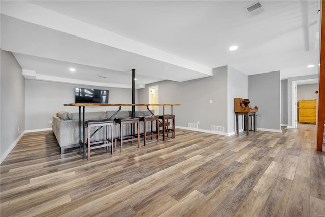 bar with baseboards, visible vents, and light wood-style floors