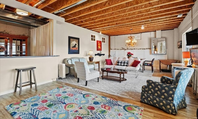 living room with radiator, an inviting chandelier, and wood finished floors