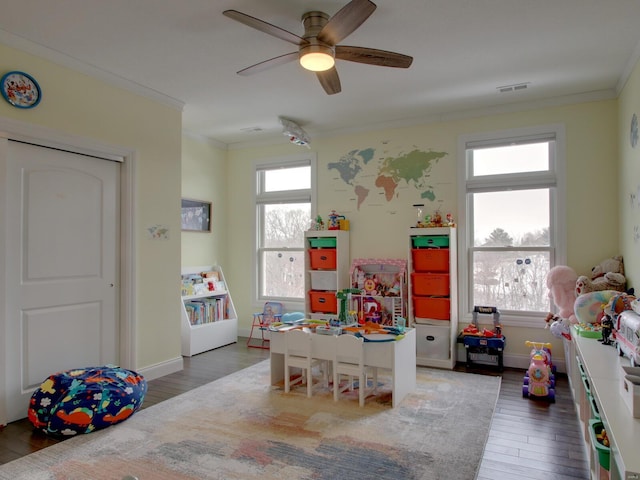 rec room with plenty of natural light, dark wood-style flooring, and crown molding