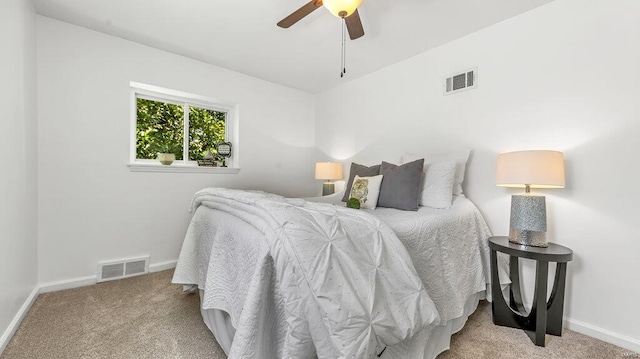 bedroom featuring visible vents, light carpet, and baseboards