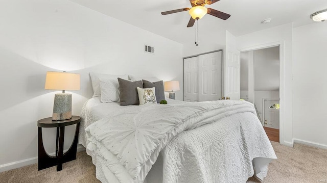 bedroom featuring a closet, visible vents, a ceiling fan, light carpet, and baseboards