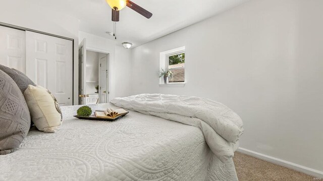 bedroom featuring a ceiling fan, a closet, baseboards, and carpet flooring