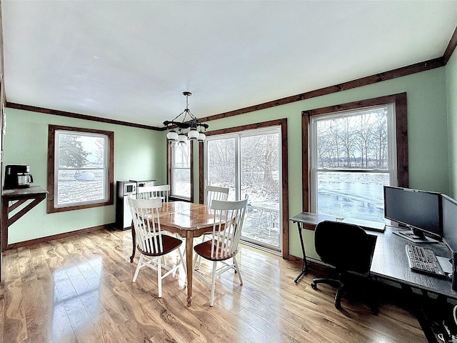 dining area featuring light wood finished floors, baseboards, ornamental molding, and a chandelier