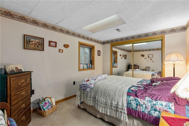 bedroom featuring a drop ceiling, carpet floors, visible vents, baseboards, and a closet