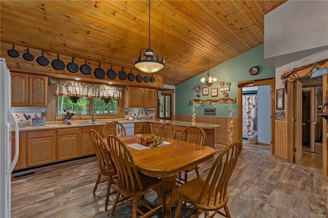 dining area featuring lofted ceiling, wood ceiling, wood finished floors, and wainscoting
