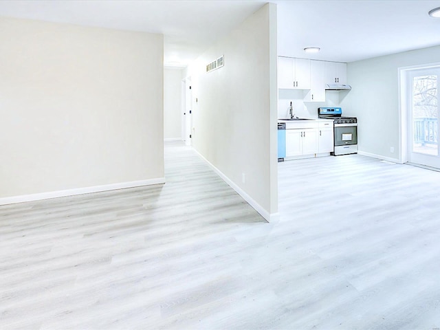 kitchen featuring light wood-style flooring, stainless steel appliances, a sink, visible vents, and white cabinetry