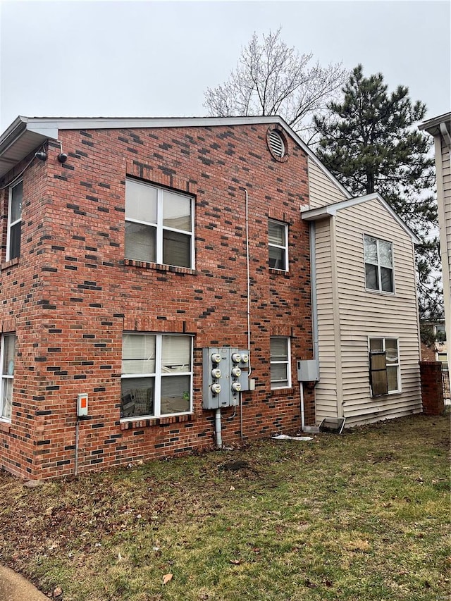 view of side of home with a yard and brick siding