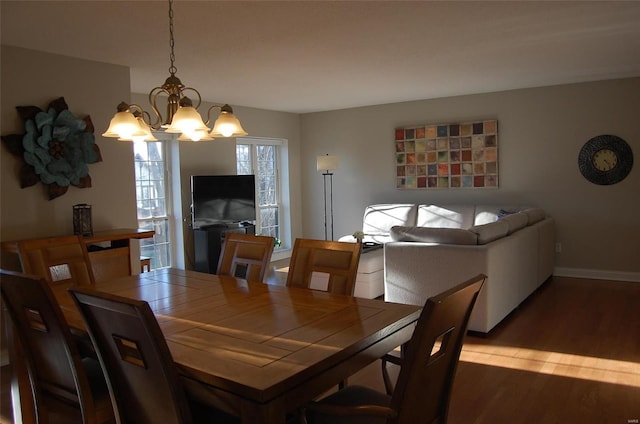 dining space with a notable chandelier, baseboards, and wood finished floors