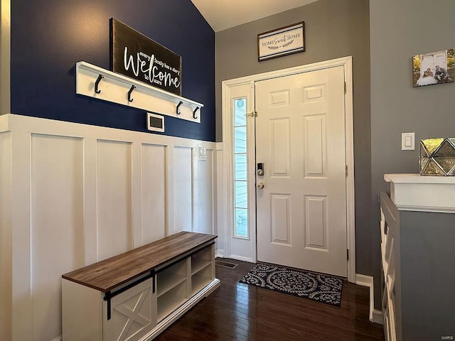 foyer featuring a wainscoted wall, dark wood-type flooring, and a decorative wall