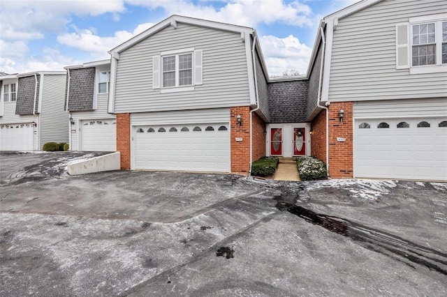 view of front of home featuring an attached garage, concrete driveway, and brick siding