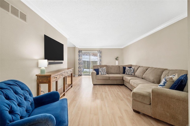 living area featuring light wood finished floors, visible vents, a textured ceiling, and ornamental molding