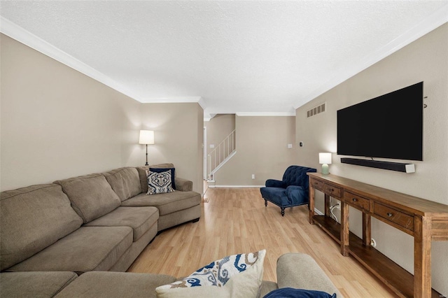 living area with light wood finished floors, visible vents, stairway, and crown molding