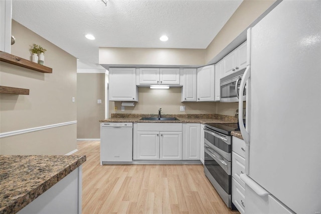 kitchen with white cabinetry, stainless steel appliances, and a sink