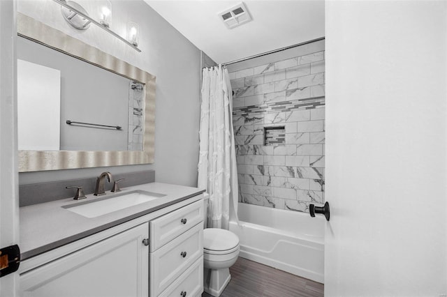 full bath with toilet, wood finished floors, vanity, visible vents, and shower / bath combo