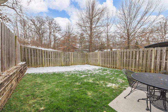 yard layered in snow featuring a fenced backyard and a patio