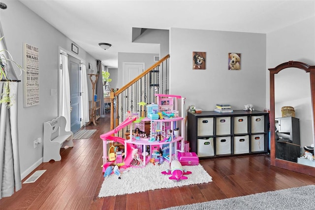 recreation room featuring dark wood-style floors, visible vents, and baseboards