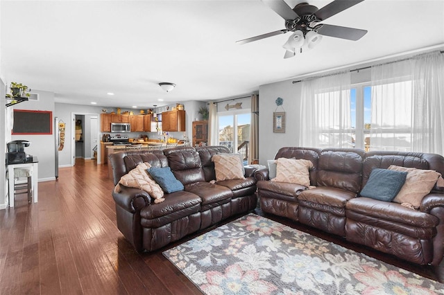 living room with a ceiling fan, dark wood-style flooring, visible vents, and baseboards