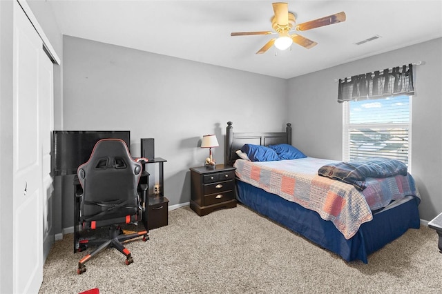 bedroom with a closet, light colored carpet, visible vents, ceiling fan, and baseboards