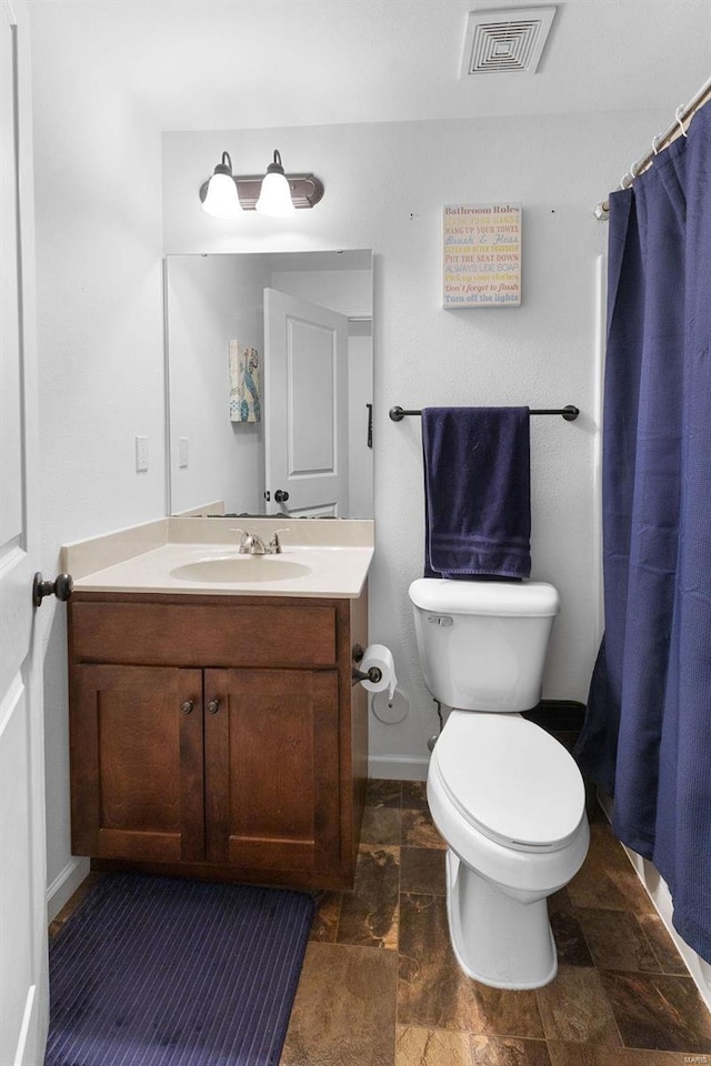 full bathroom with visible vents, baseboards, toilet, stone finish floor, and vanity