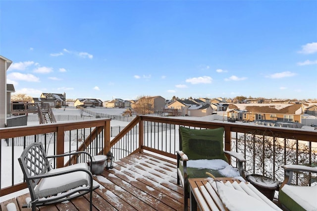 snow covered deck featuring a residential view