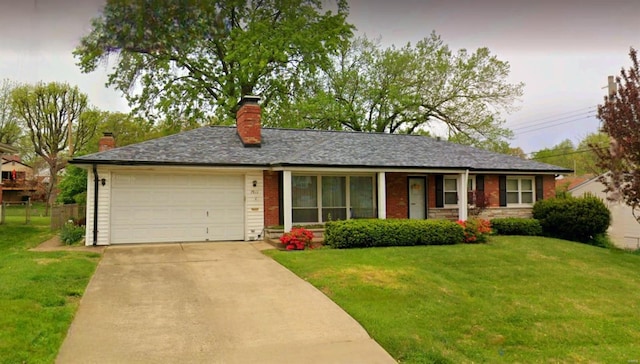 single story home with driveway, a chimney, an attached garage, a front lawn, and brick siding