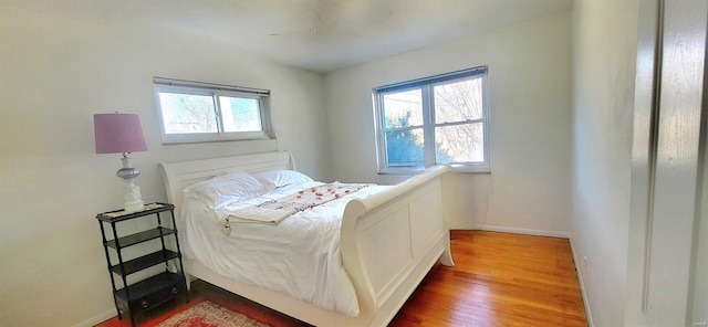 bedroom with baseboards and wood finished floors