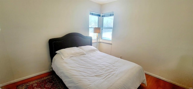 bedroom featuring baseboards and wood finished floors