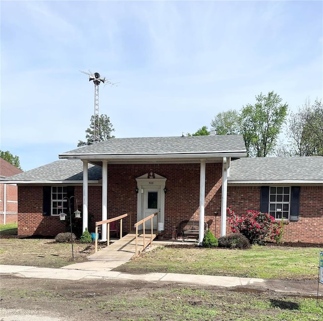 ranch-style house featuring a shingled roof and brick siding