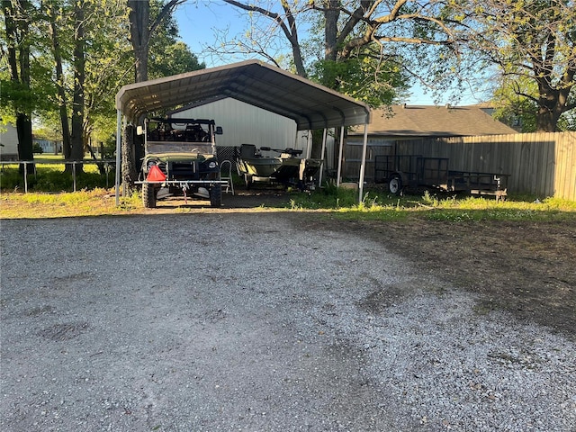 view of parking / parking lot with a carport, fence, and driveway