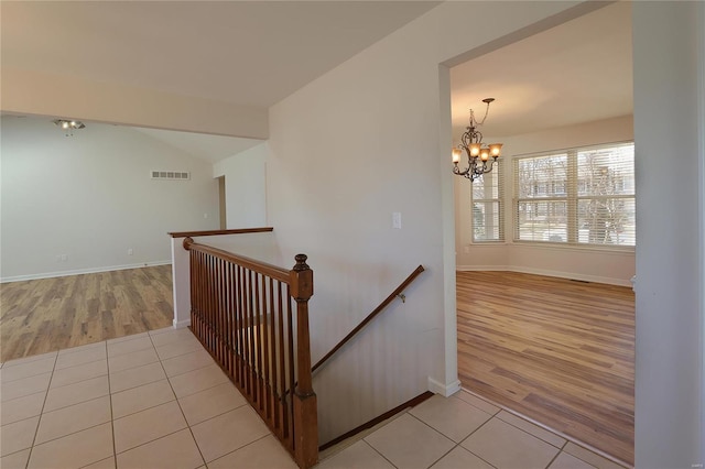 stairs with baseboards, visible vents, a chandelier, and tile patterned floors