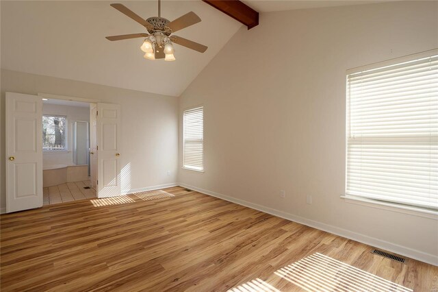 interior space featuring a ceiling fan, visible vents, baseboards, beam ceiling, and light wood finished floors