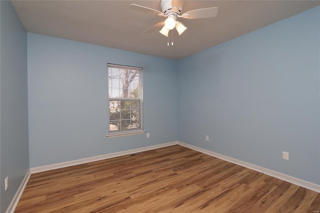 unfurnished room featuring ceiling fan, visible vents, baseboards, and wood finished floors