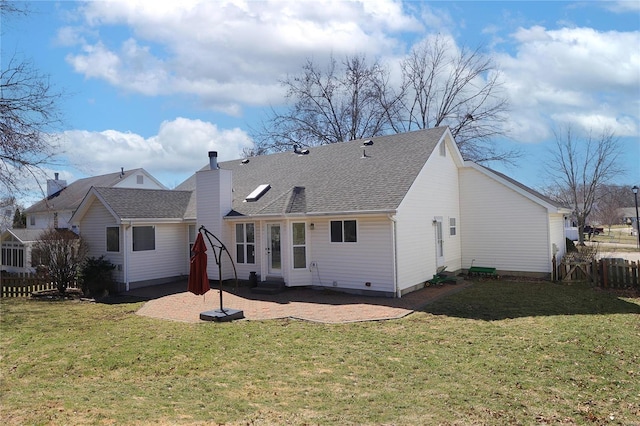 back of property with entry steps, a lawn, a patio area, and fence