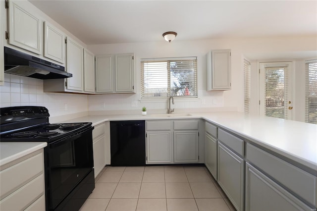 kitchen featuring black appliances, a healthy amount of sunlight, a sink, and under cabinet range hood