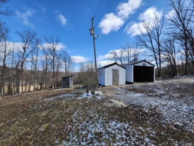 exterior space with a pole building, an outdoor structure, and a detached garage