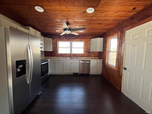 kitchen with stainless steel appliances, wooden ceiling, and white cabinets