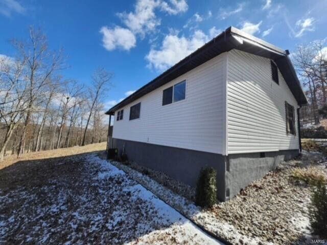 view of snow covered exterior with crawl space