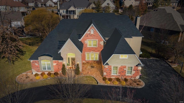 view of front of house with driveway, a shingled roof, a chimney, and brick siding