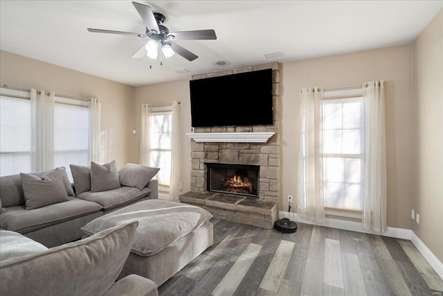 living room with a fireplace, wood finished floors, a wealth of natural light, and baseboards