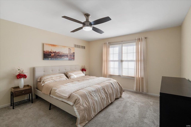 bedroom featuring baseboards, visible vents, ceiling fan, and light colored carpet