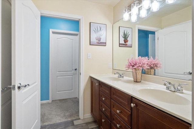 full bath with a sink, baseboards, and double vanity