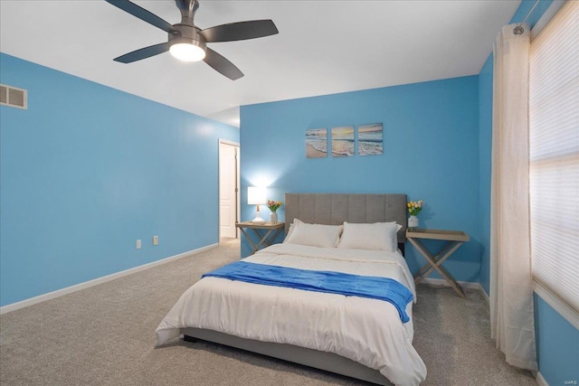 carpeted bedroom with a ceiling fan, visible vents, and baseboards