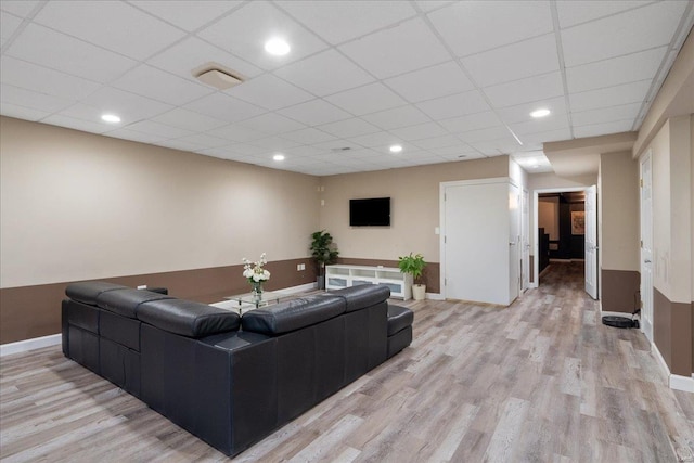 living room with baseboards, recessed lighting, a paneled ceiling, and light wood-style floors